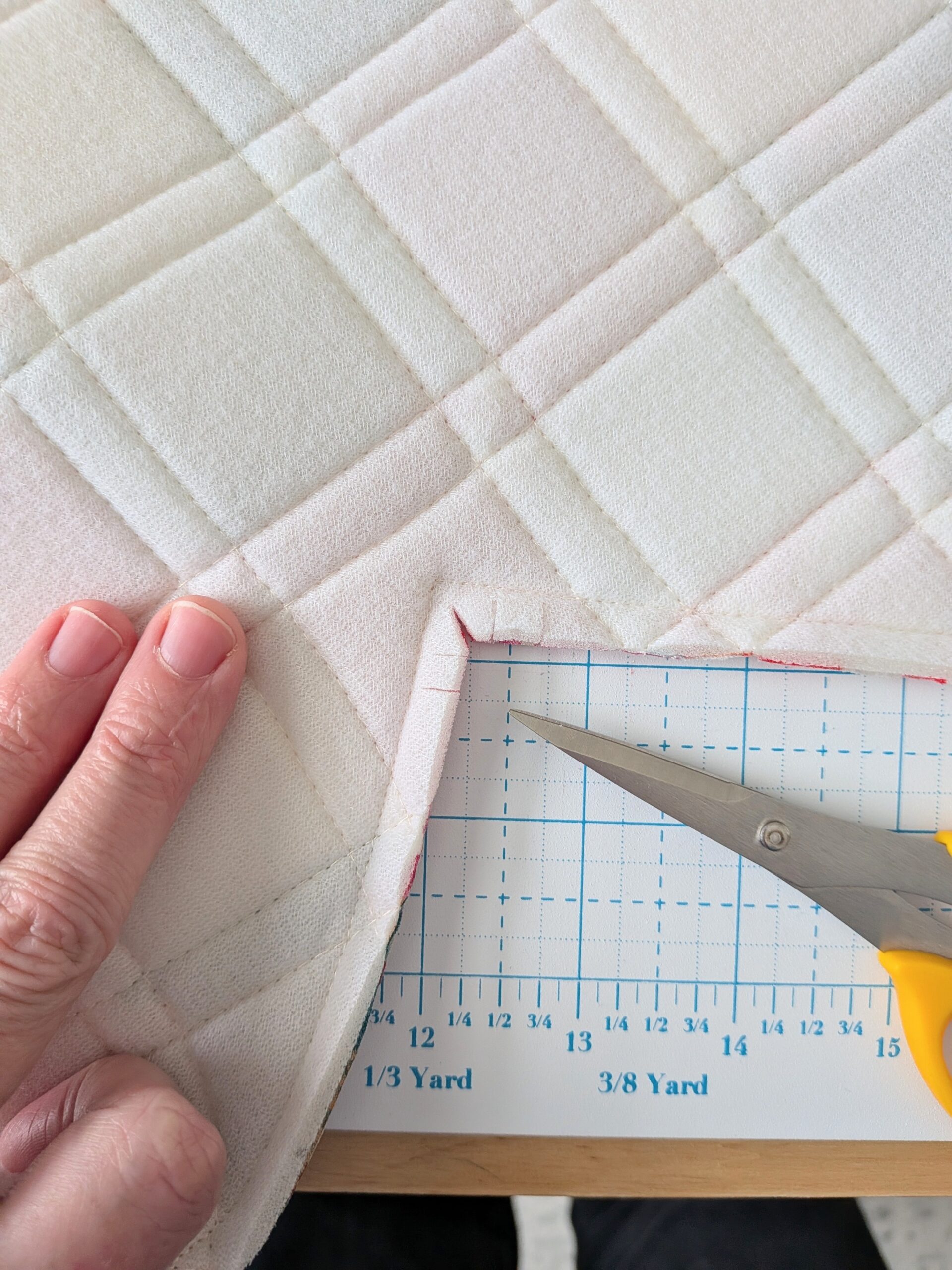 A closeup view of some small cuts made in a quilted piece of foam.