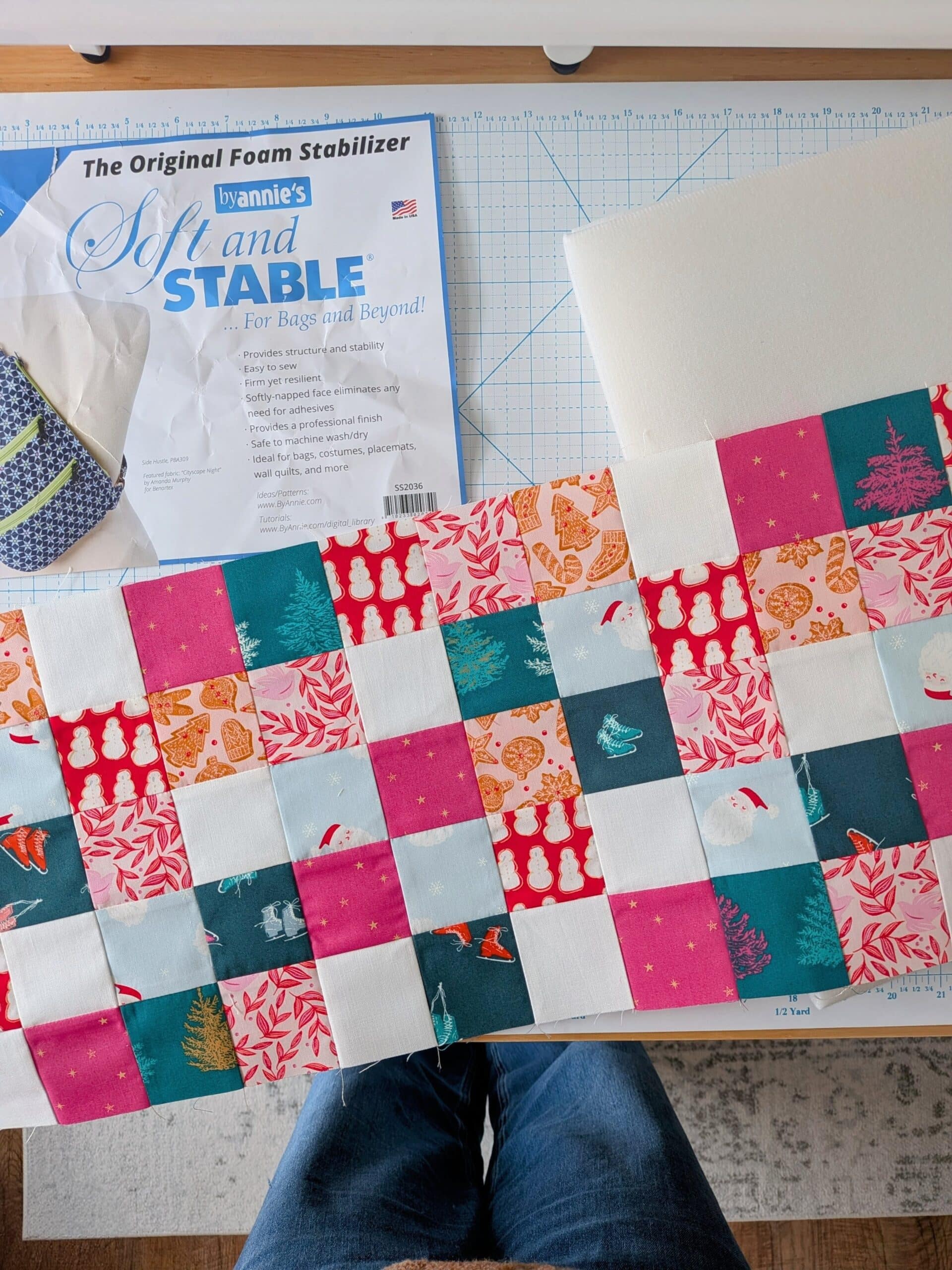 A patchwork panel lies on top of a cutting mat with a package of Soft and Stable.
