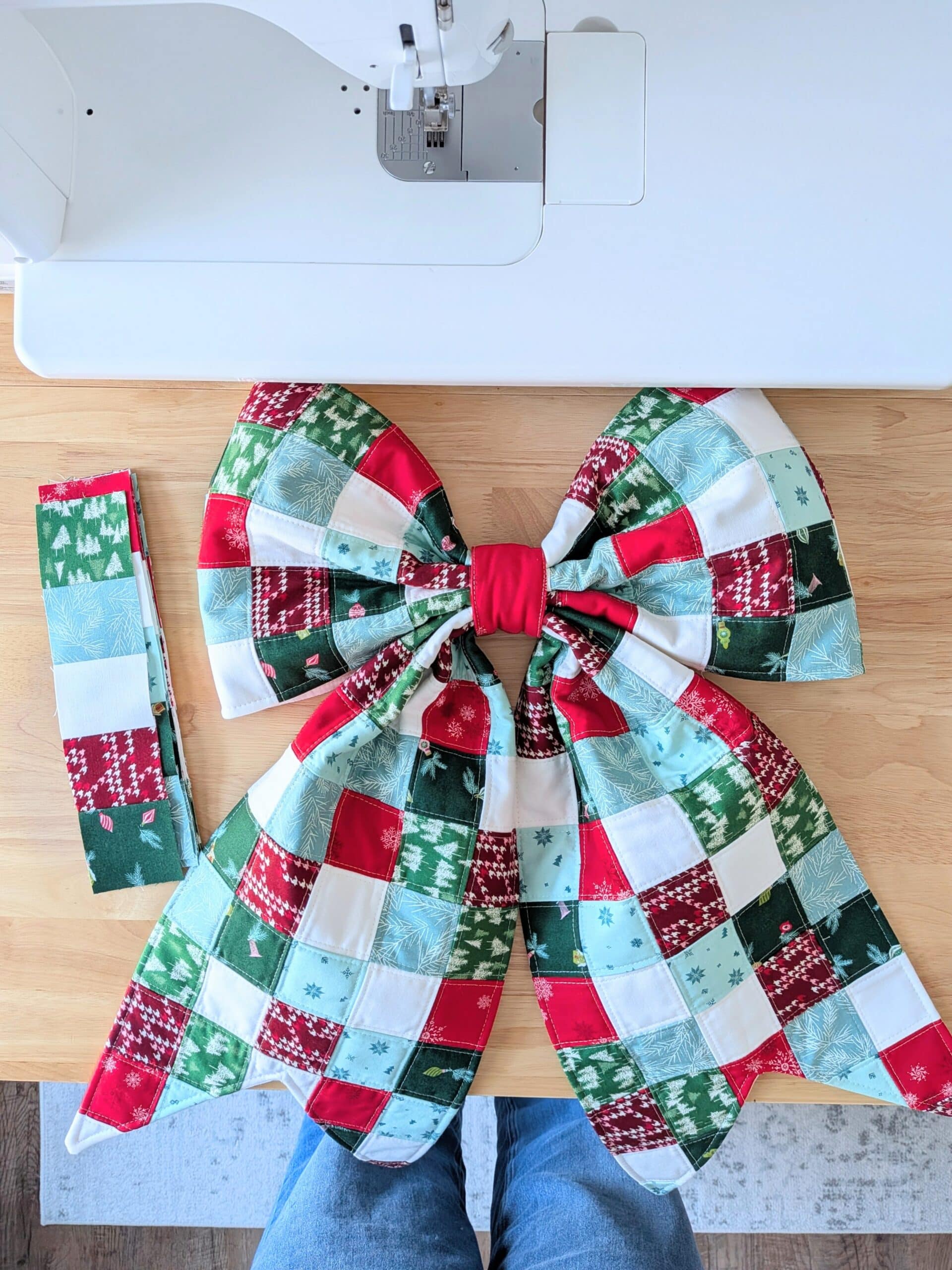 Overhead view of a patchwork bow lying on a worktable.