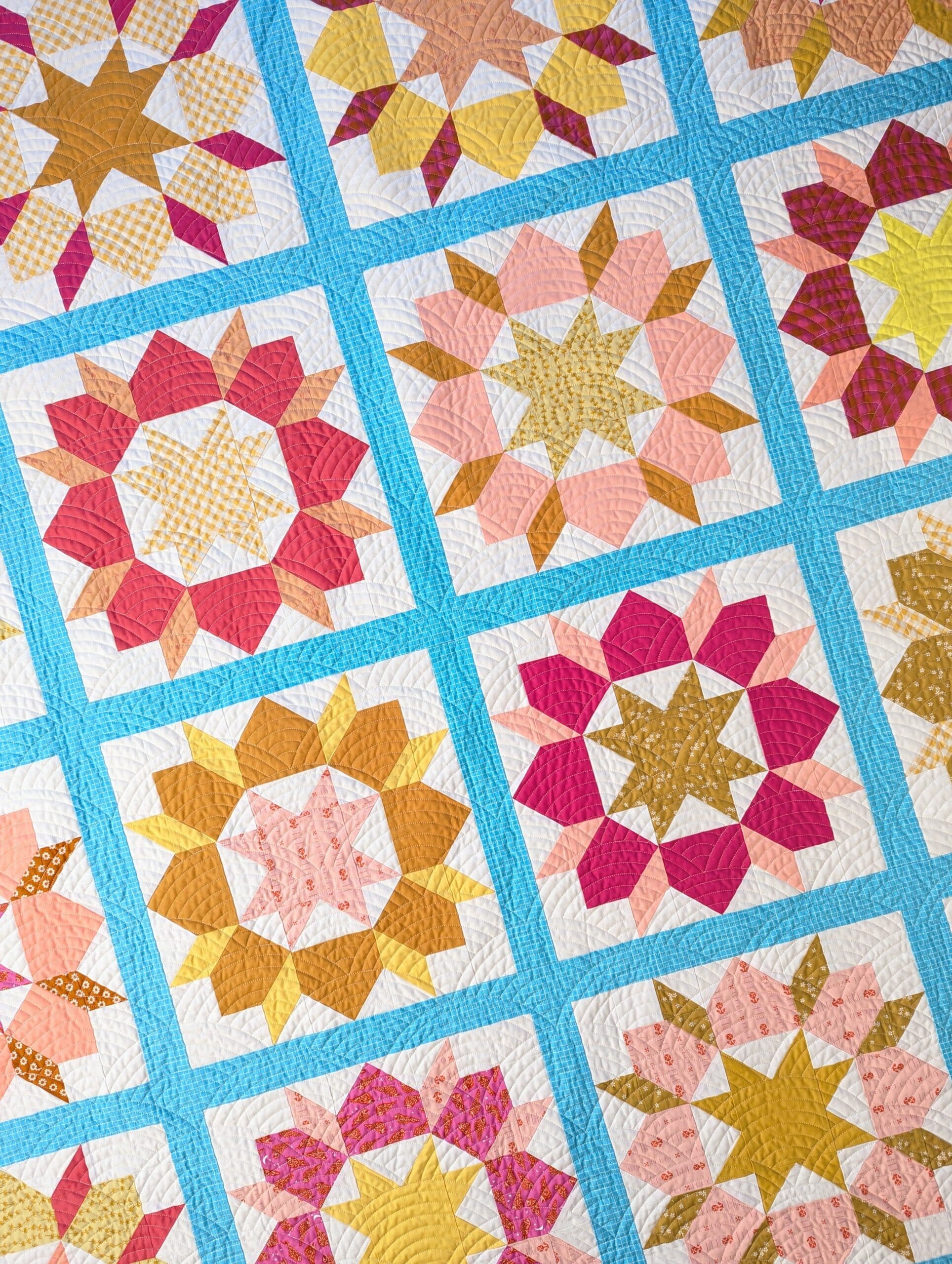 The completed quilt lies on the floor and is seen from above.