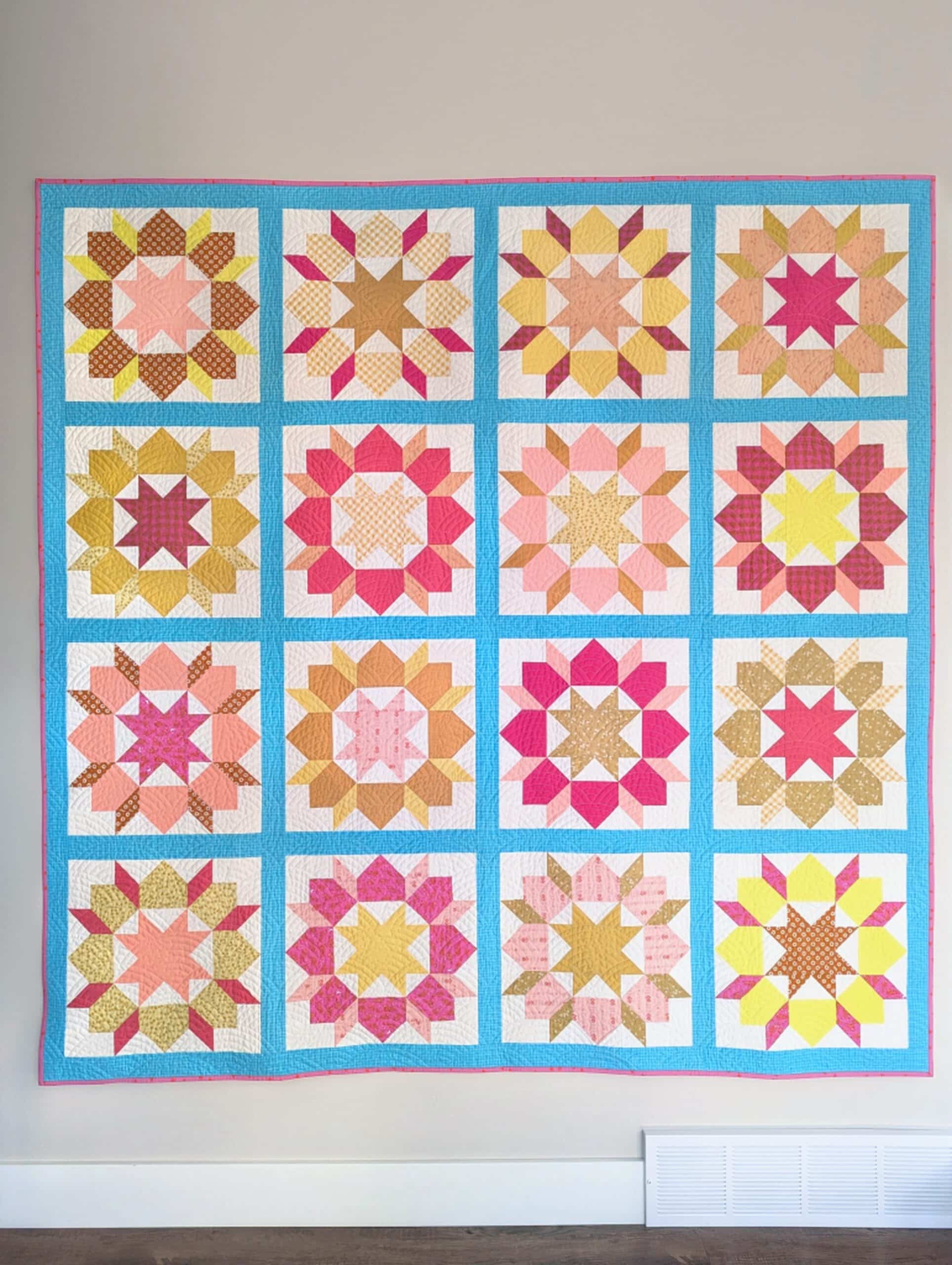 The finished quilt is affixed to a wall, showing every part of the quilt top at once.