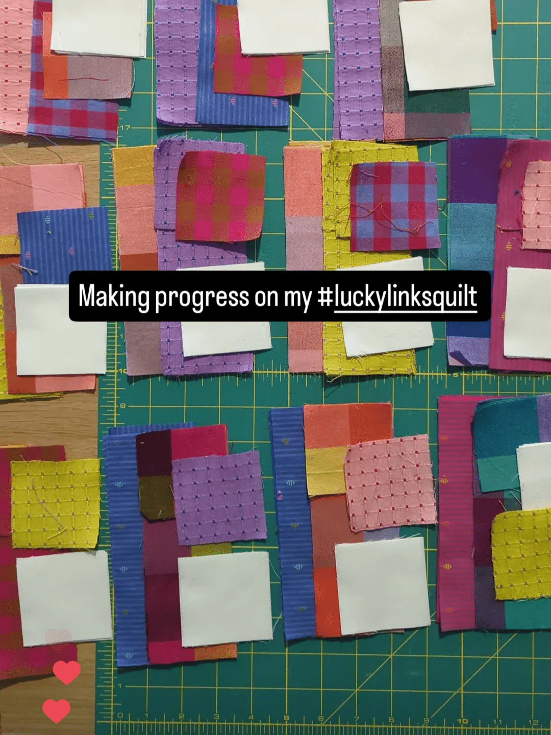 Several stacks of different coloured fabric lie on a green cutting mat with the text overlay "making progress on my #luckylinksquilt".