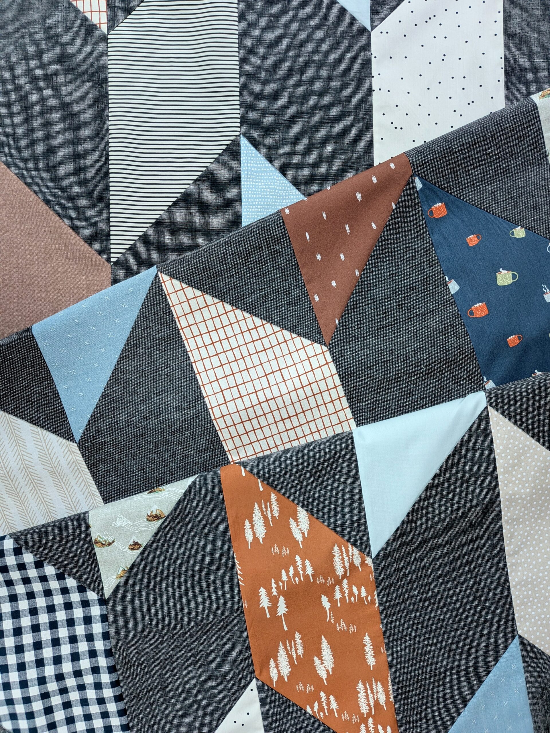 A chevron quilt top is folded onto itself twice.