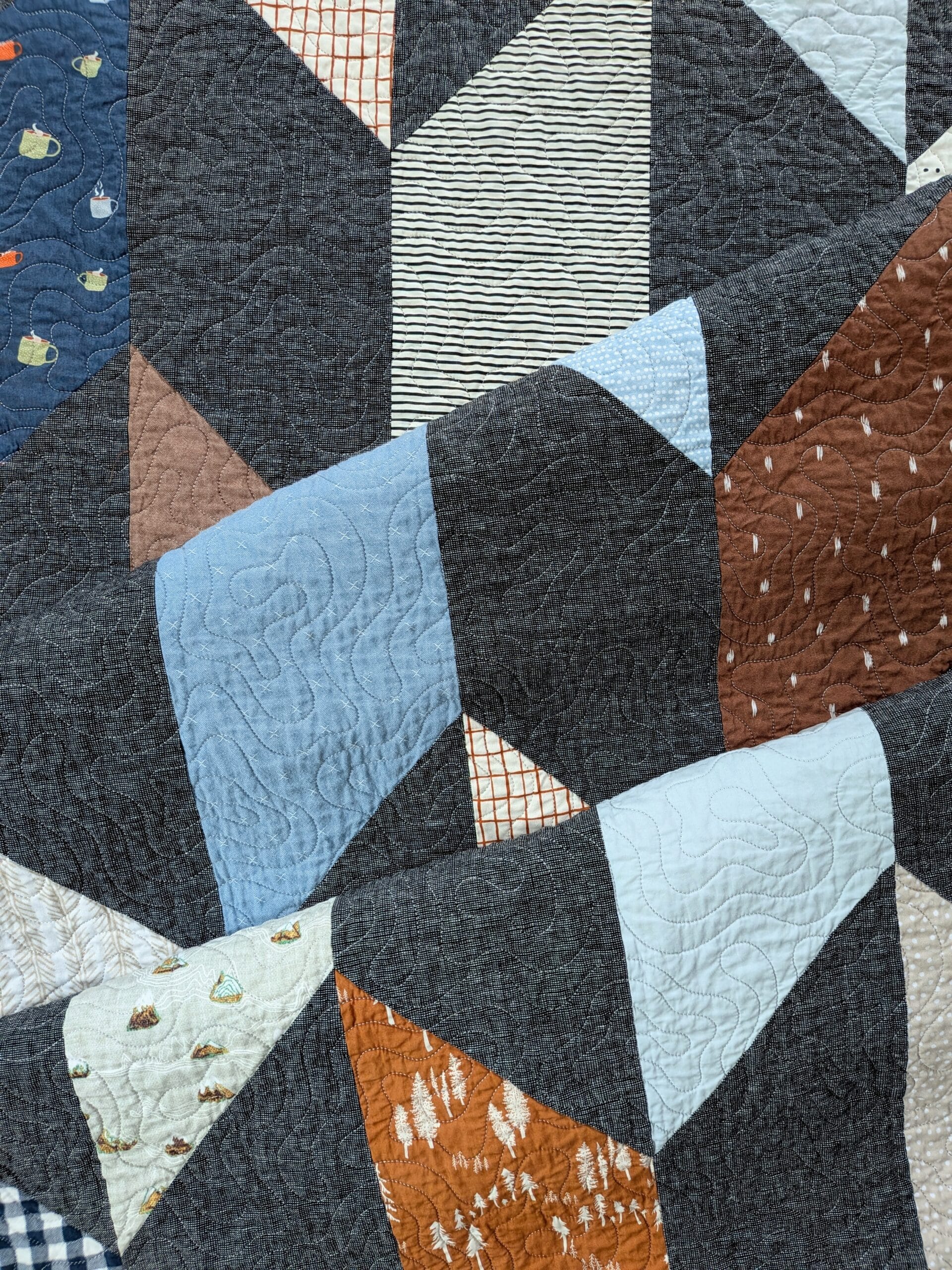 A chevron quilt is folded onto itself twice.