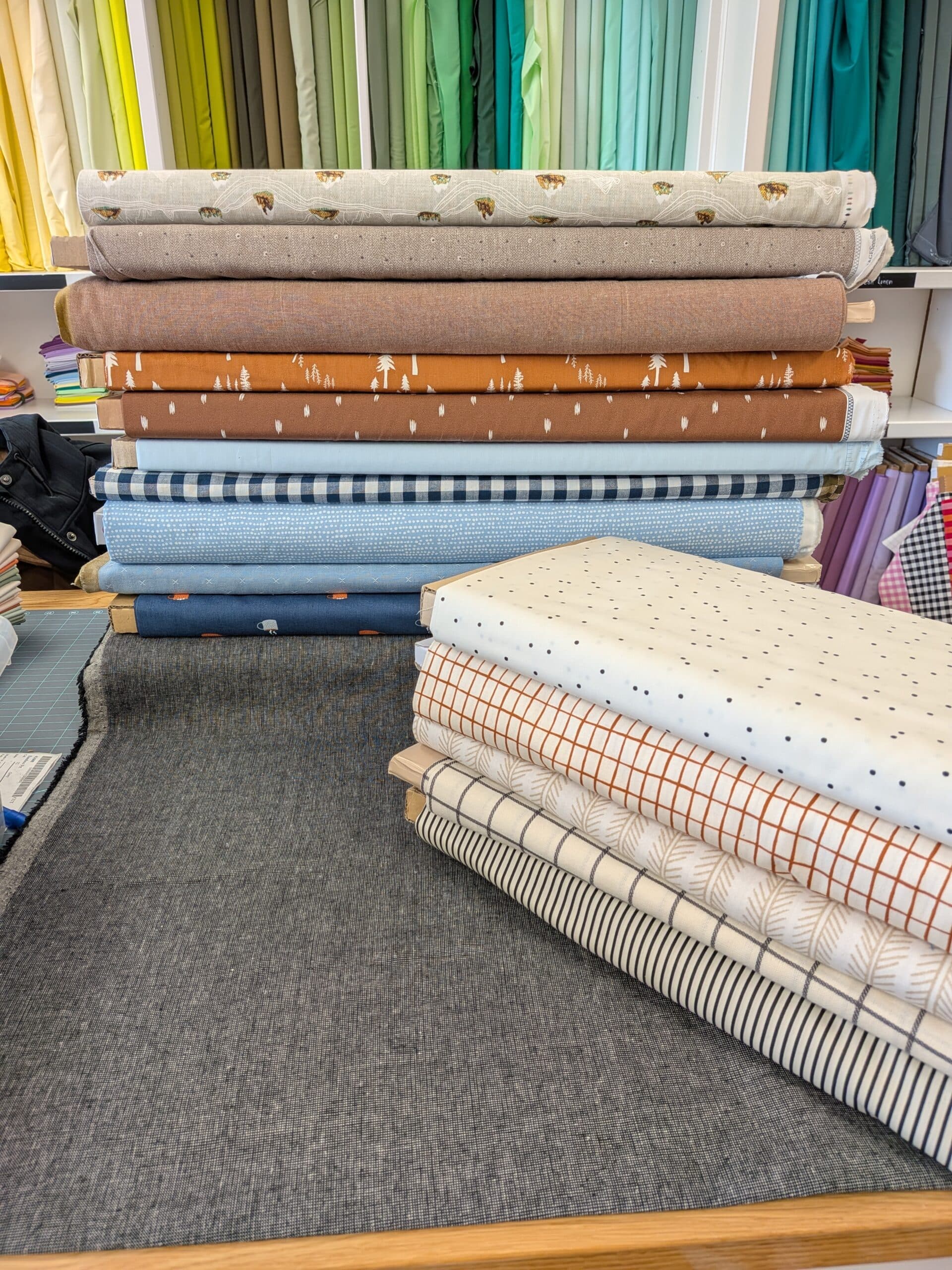 Bolts of fabric are stacked on top of each other inside a quilt shop.