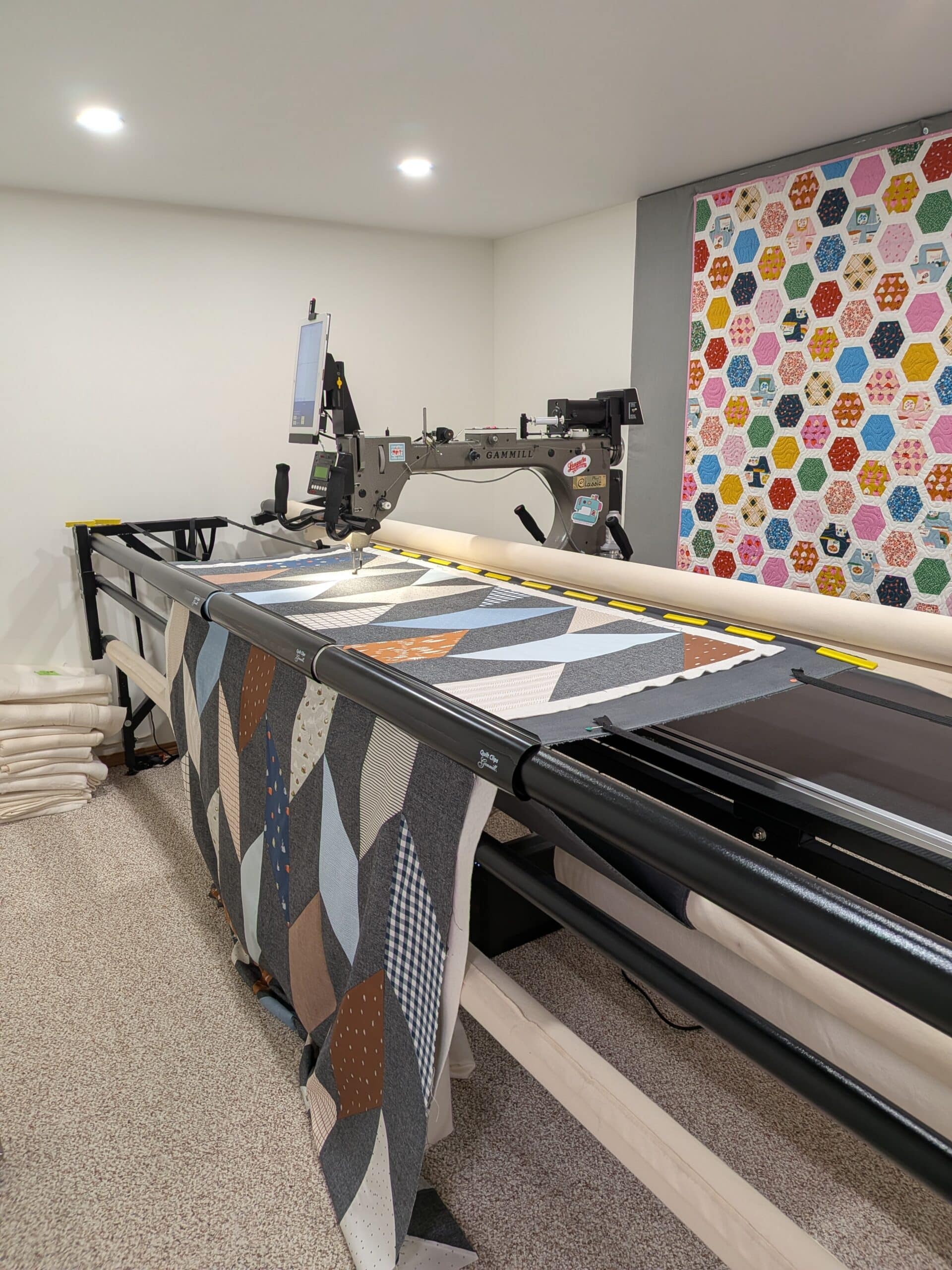 A chevron quilt is loaded on a longarm machine.