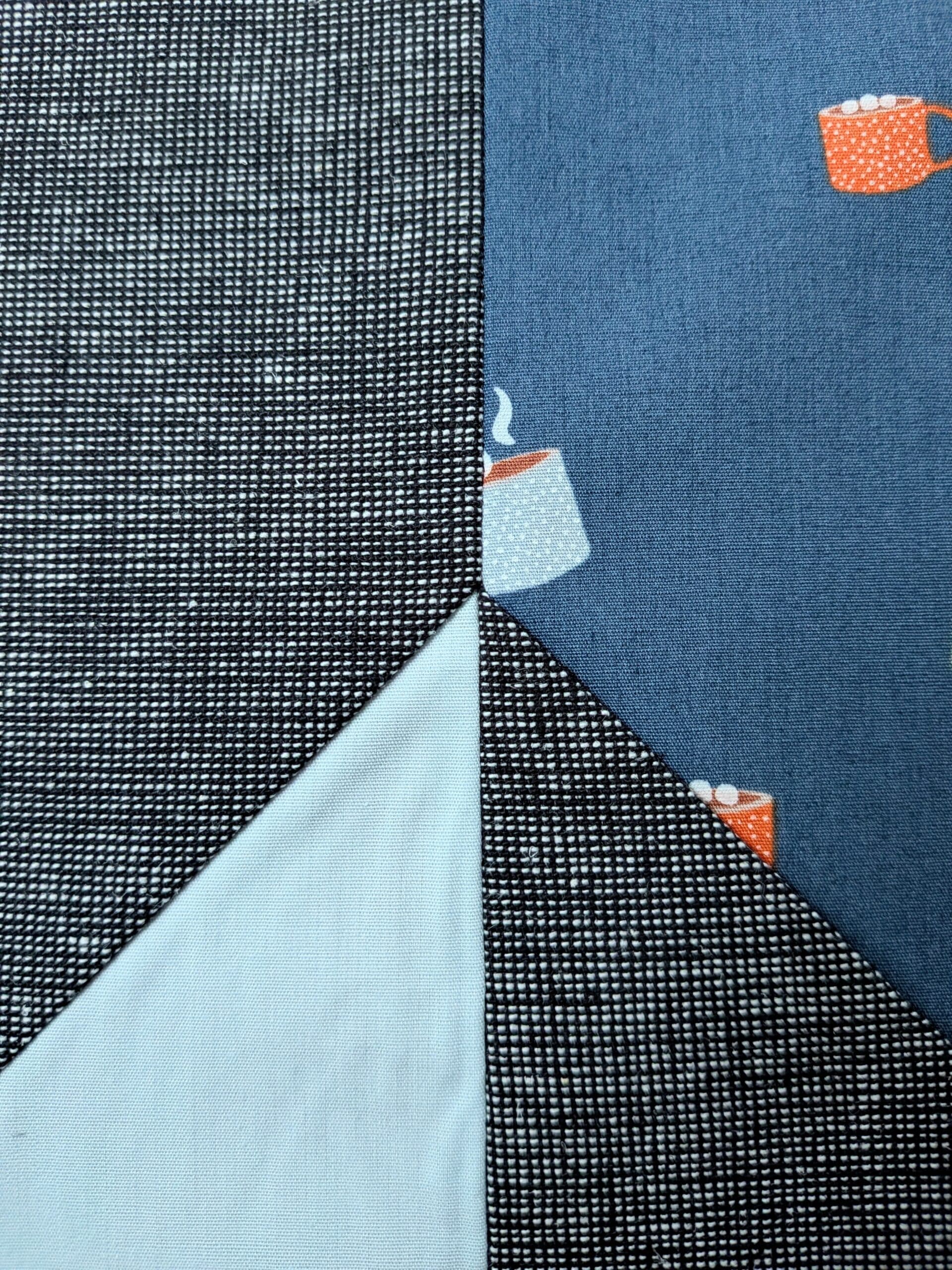 Extreme closeup look at the point where two quilt blocks meet.
